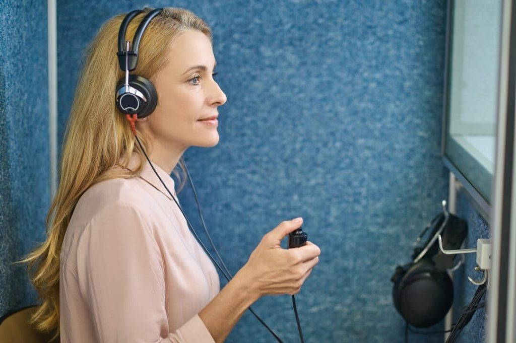 a woman wearing headphones and holding a remote