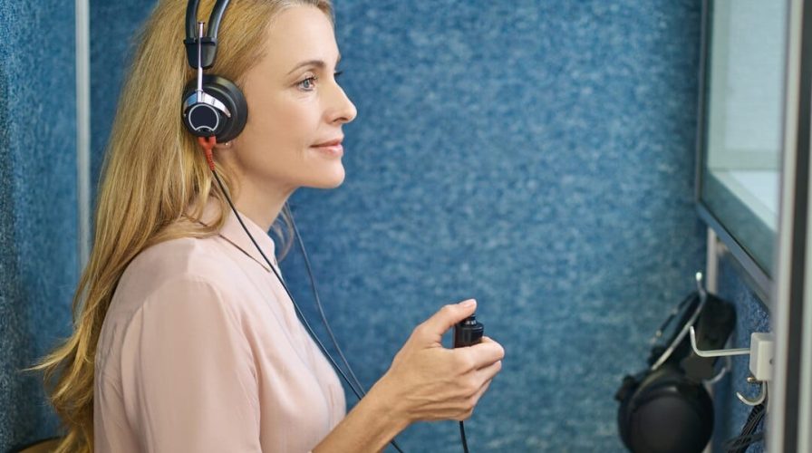 a woman wearing headphones and holding a remote